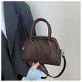 Minimalist baguette handbag in dark brown matte leather with adjustable shoulder strap - Brown