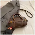 Borsa Boston marrone scuro con trama litchi, cuciture bianche e dettagli dorati - senza ciondolo / Marrone
