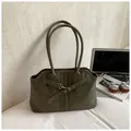 Olive green faux leather tote bag with silver buckle straps in a workspace setting - No Pendant / Green