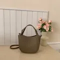 Elegant dark beige lychee texture bucket bag with glancy logo and thin shoulder strap - Gray
