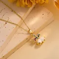 Detailed close-up of a gold necklace featuring colorful gemstone ribbon and bell charms - Christmas Bell
