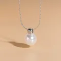 Detailed close-up of a round white pearl pendant with a minimalist silver chain - Pearl Necklace (XL8005Y) / Steel