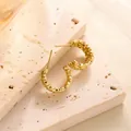 Detailansicht goldener C-förmiger Ohrringe mit Diamantschliff-Textur auf Stein - Diamantschliff-Texturstil (ED043) / Gold