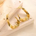 Detailansicht großer vergoldeter dreischichtiger Wellenohrringe auf Steinstruktur - Dreilagiger Flachwelliger Verflochtener Stil (ED046) / Gold