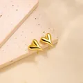 Detailed view of 18k gold plated heart-shaped stud earrings on a beige stone slab - Heart Stud Earrings (ED131) / Gold