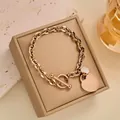 Details des roségoldenen Herzarmbands aus Titan mit einem besetzten runden Charm - Vollständiges Strassherz OT Armband / Roségold