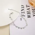 Close-up of silver stainless steel heart chain bracelet with intricate floral engravings - Bracelet / Steel