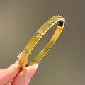 Gouden klaver armband van titanium staal met sprankelende strass steentjes dames - Goud