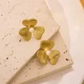 Γαλλικά σκουλαρίκια λουλούδια 18k χρυσά με πέρλα στο κέντρο πάνω σε πέτρινο φόντο - Σκουλαρίκι με Τεχνητό Μαργαριτάρι Λουλούδι με Τρία Πέταλα (Χρυσό)