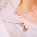 Detailed macro view of a large white pearl pendant on a gold necklace with stone accents - Pearl Lucky Bag - O-Chain - Gold