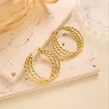 Detail von geometrischen gedrehten Creolen mit 18 Karat Goldbeschichtung und Textur - Mehrschichtiger Wellen-Twist-Reif (EH055)