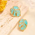 Elegant gold titanium monstera leaf stud earrings with marble blue enamel inlay - Cyan