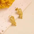 Detailed macro of golden stainless steel palm leaf studs on a stone pedestal - Feather Leaf (ED203) / Gold