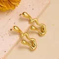 Detailed close-up of golden wavy earrings with a liquid metal texture on stone surface - Abstract Wave (ED144) / Gold