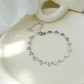 Detail eines silbernen Herzkettenarmbands mit Sonnenstrahl-Textur und Karabinerverschluss - Silbernes Armband