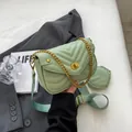 Detailed close-up of mint green quilted crossbody bag with golden chain and round coin purse - Light Green