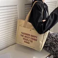 Große beige Segeltuch-Tragetasche mit Vordertasche und Buchstabendruck für den Alltag - Khaki