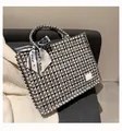 Checkered canvas tote bag with fringed edges and decorative scarf on a grey sofa - Black Large