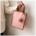 Detalle del bolso tote de cuero rosa con bordes trenzados marrones y etiqueta moda - Producto terminado / Rosa
