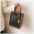 Detalle de bolso tote negro con bordes trenzados marrones y cadena dorada - Producto terminado / Negro