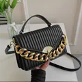 Schwarze Handtasche mit Plissee-Design, goldener Kette und fächerförmigem Verschluss - Schwarz