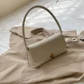 Retro cream shoulder bag with textured leather panel and vintage gold metal clasp - White