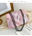 Macro view of pink snake pattern texture and black chain strap on luxury small square bag - Pink