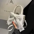 White PU leather handbag featuring a large organza bow and detachable gold hardware strap - White