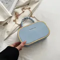 Lichtblauwe ovale box tas met gevlochten handvat, gouden ketting en metalen frame - Blauw
