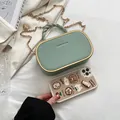 Muntgroene mini box tas met litchi textuur, goudkleurig frame en geweven handvat - Lichtgroen
