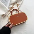 Bruine leren box-tas met goudkleurig frame, gevlochten handvat en gouden ketting - Oranjerood