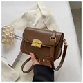Sac bandoulière marron foncé à texture croco et boucle dorée en forme de chocolat - café