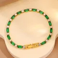 Gros plan du bracelet tennis doré orné de gemmes vert émeraude et de zircons - Bracelet Entièrement en Zircone Vert Émeraude / Vert