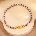 Détail d'un bracelet doré orné de zircons violets et blancs sur un support élégant - Bracelet Entièrement en Zircone Violet / Violet