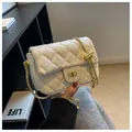 Elegante cremefarbene Stepptasche mit goldener Kette und quadratischem Drehverschluss - Cremeweiß