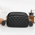 Fashionable black quilted crossbody bag with golden zippers and wide textile strap - Black