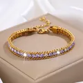Détail d'un bracelet en titane doré avec cristaux violets sur une boîte à bijoux - Bracelet Or Violet Clair Zircone Blanche