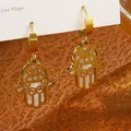 Vue macro de boucles d'oreilles Main de Fatma dorées avec incrustation en nacre - Style Évidé en Nacre (No.3 Boucles d'oreilles Œil de Diable et Paume)
