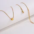 Détail du collier chaîne serpent dorée avec pendentif étoile sur support blanc - Collier Étoile Doré