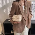 Beige gewatteerde leren crossbodytas met verstelbare gouden ketting gedragen door model - Klein / Wit