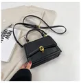 Elegante zwarte leren handtas met een gouden dubbele ring sluiting en verstelbare riem - Zwart