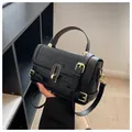 Borsa nera con trama a coccodrillo, chiusura a scatto dorata e tracolla regolabile - Nero