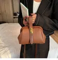 Detail of brown litchi pattern leather handbag with vintage gold metal twist lock - Brown