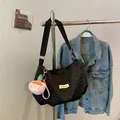 Bolso bandolera negro con textura de burbujas, colgante de peluche rosa y etiqueta de logo - Con Colgante de Melocotón / Negro