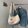White pleated cloud shoulder bag with peach plush charm and wide adjustable strap - White