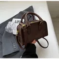 Detail of dark brown vintage Boston bag with gold hardware and embossed ORN ORN logo - Coffee