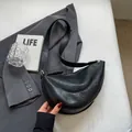 Minimalist black crescent moon shoulder bag in textured faux leather with wide strap - Black