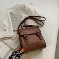 Braune Vintage-Umhängetasche aus Leder mit goldenen Beschlägen in einem Flat Lay - Braun
