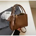 Bolso de mano marrón oscuro en cuero con patrón de lichi y un pañuelo de seda a cuadros - Marrón