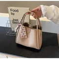 Beige litchi grain leather handbag with a patterned scarf handle and metal hardware - Khaki
